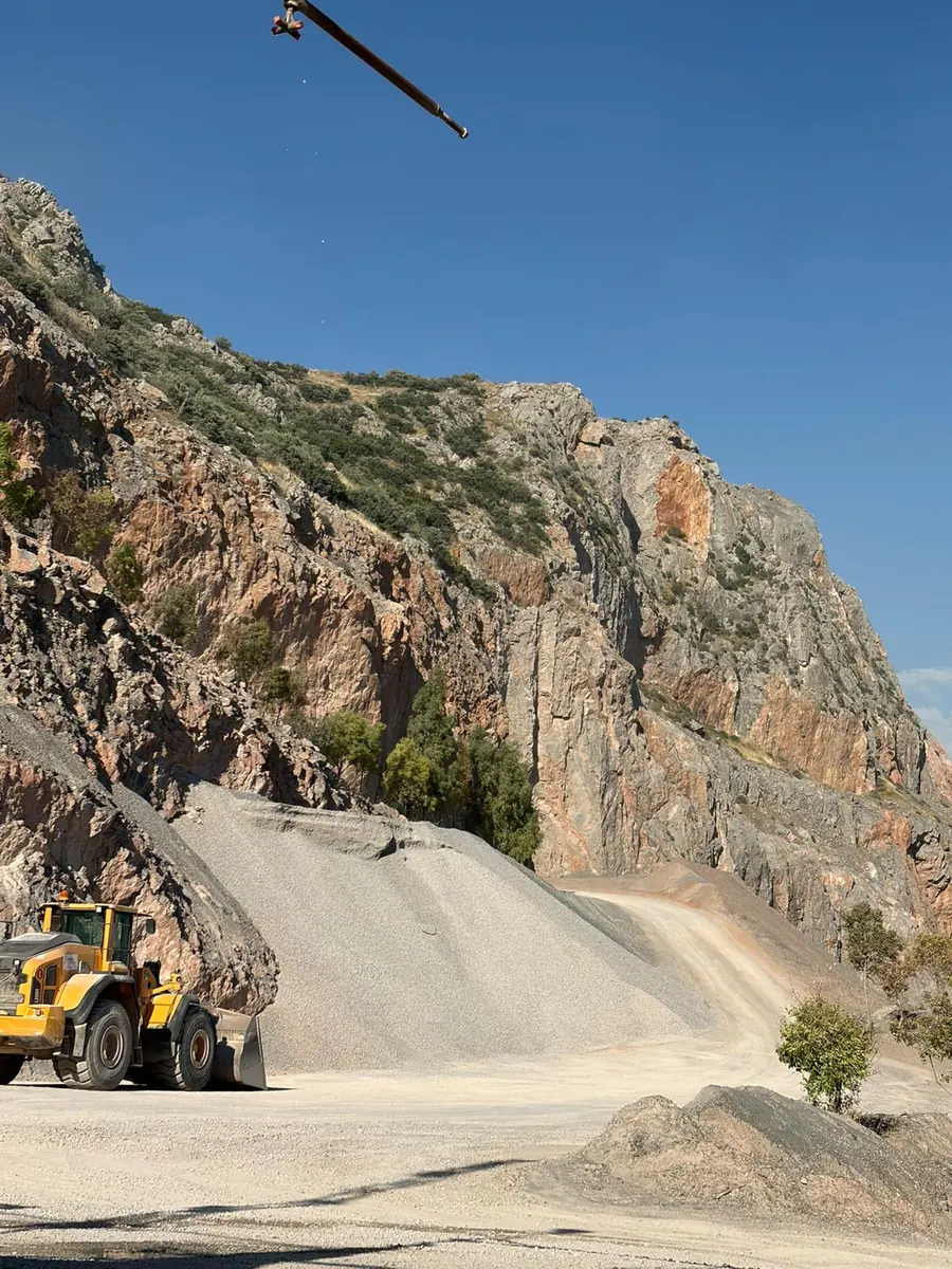 İzmir taş ocağında kırmataş yığınlarının yanında çalışan lastikli yükleyici